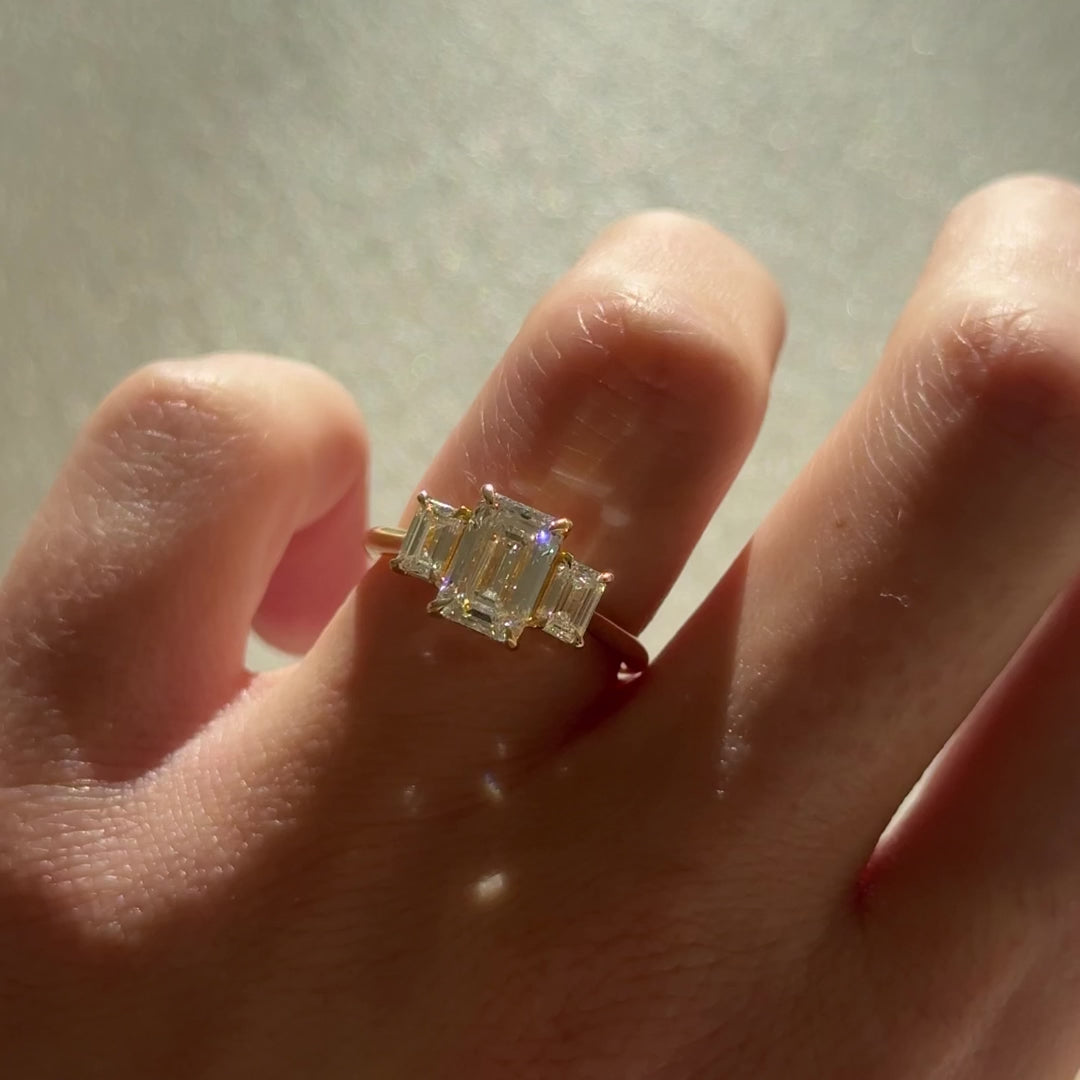 טבעת אירוסין שלוש אבנים 1.5 קראט יהלום אמרלד ואבני צד אמרלד